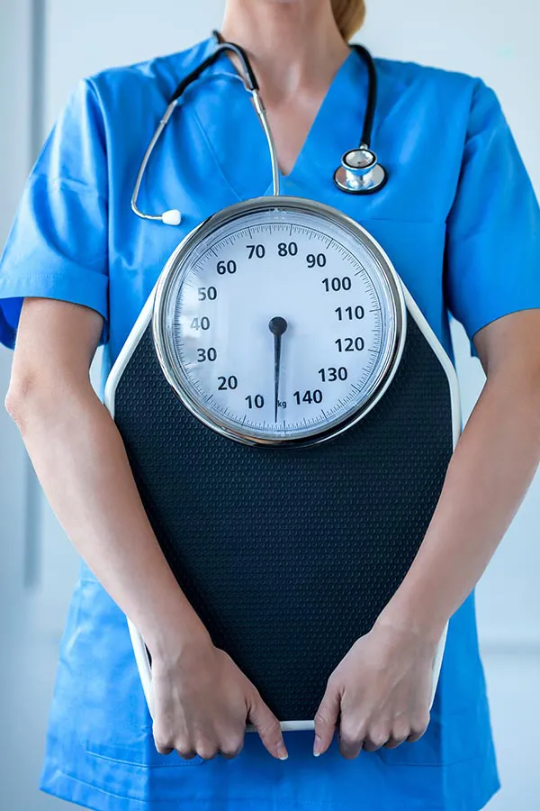 43-Day-HCG-Weight-Loss-Treatment A clinician holding a scale. Learn about the 43-day HCG weight loss program at Jennifer Jose-Cappola, MD in Stamford.