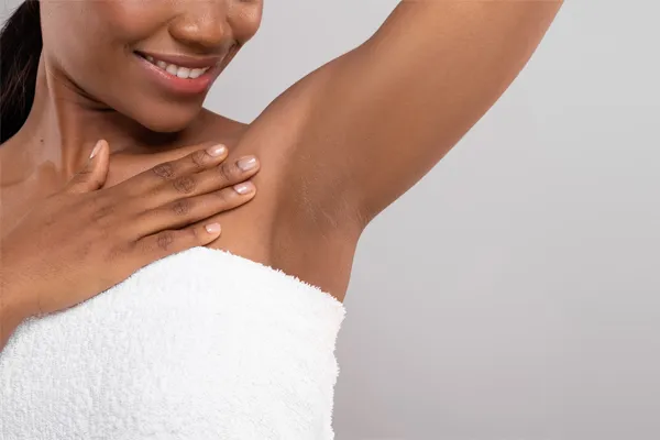 Daxxify-for-Excessive-Sweating-Clinic Close up of an African American woman wrapped in a white towel showing her underarm area. Visit Daxxify® for excessive sweating specialist Jennifer Jose-Cappola, MD in Stamford.