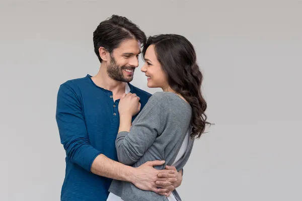 Erectile-Dysfunction-Doctor A man in a blue shirt embracing a woman in a gray shirt smiles due to his successful erectile dysfunction care from Jennifer Jose-Cappola, MD in Stamford.