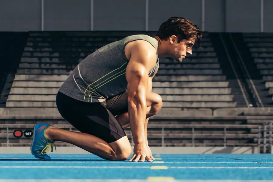 Lean-Muscle-and-Recovery-Clinic A white man kneels at the starting line on a track, determined to do his best. Get treatment for lean muscle loss and recovery from Jennifer Jose-Cappola, MD in Stamford.