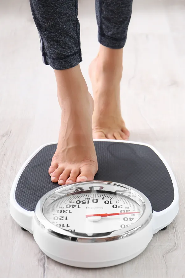 Obesity-Treatment Close up of feet stepping onto a scale. Receive expert functional medicine for obesity treatment by Jennifer Jose-Cappola, MD in Stamford.