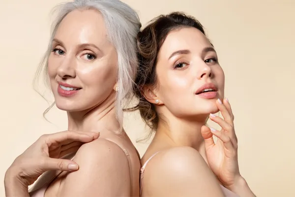 Skincare-Solutions-Clinic A mature woman with silver hair and a young woman both show their beautiful radiant skin. Get skincare solutions from Jennifer Jose-Cappola, MD in Stamford.